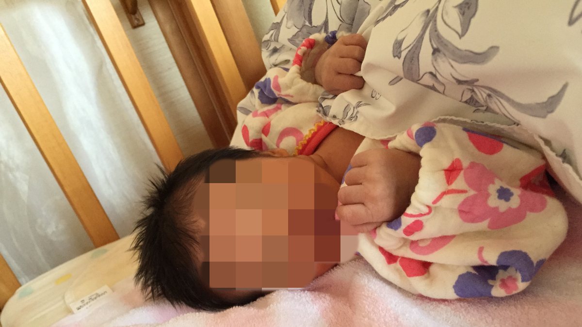 実家で借りたベビーベッドで眠る新生児